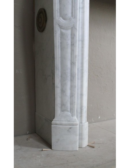 Cornice antica da camino "Pompadour" scolpita in candido marmo bianco Carrara e con bocche in bronzo decorate.
