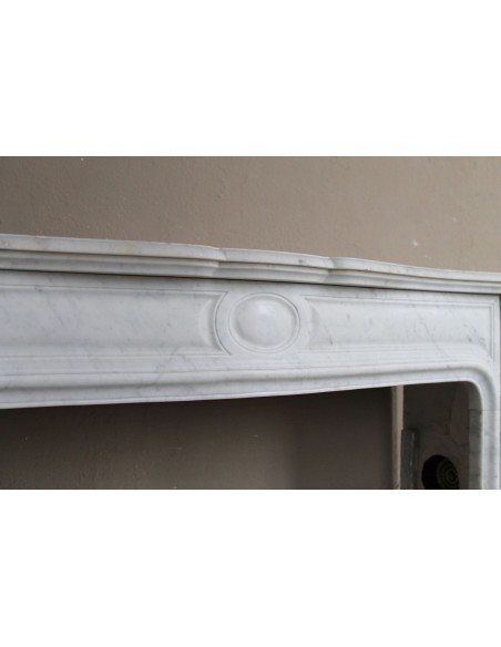 Cornice antica da camino "Pompadour" scolpita in candido marmo bianco Carrara e con bocche in bronzo decorate.