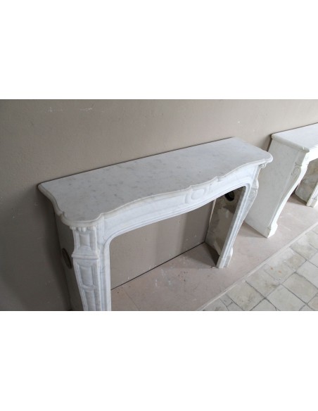 Cornice antica da camino "Pompadour" scolpita in candido marmo bianco Carrara e con bocche in bronzo decorate.