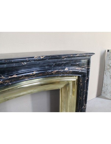 Camino antico Luigi XIV "Boudin" in eccezionale marmo nero Portoro provvisto di controcuore originale in ottone dorato.