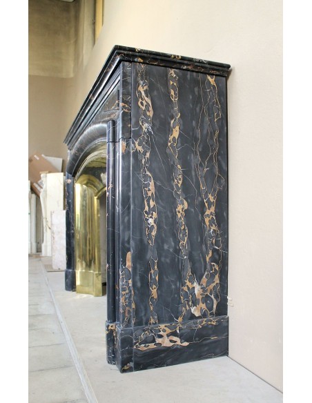 Camino antico Luigi XIV "Boudin" in eccezionale marmo nero Portoro provvisto di controcuore originale in ottone dorato.