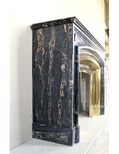 Camino antico Luigi XIV "Boudin" in eccezionale marmo nero Portoro provvisto di controcuore originale in ottone dorato.