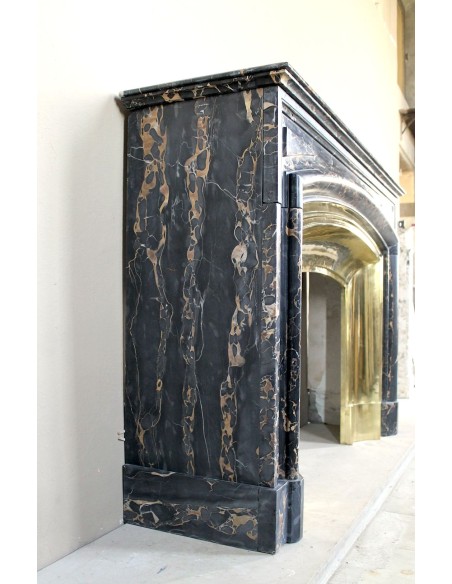 Camino antico Luigi XIV "Boudin" in eccezionale marmo nero Portoro provvisto di controcuore originale in ottone dorato.