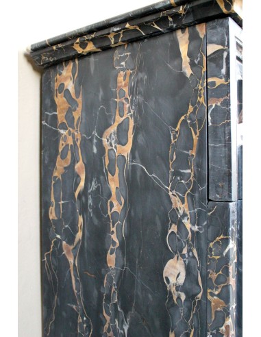 Camino antico Luigi XIV "Boudin" in eccezionale marmo nero Portoro provvisto di controcuore originale in ottone dorato.