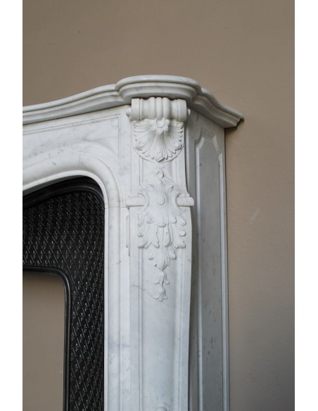 Camino antico Luigi XV "Moustache" in marmo Bianco Carrara "Puro" con controcuore in ghisa artistica a decori floreali.