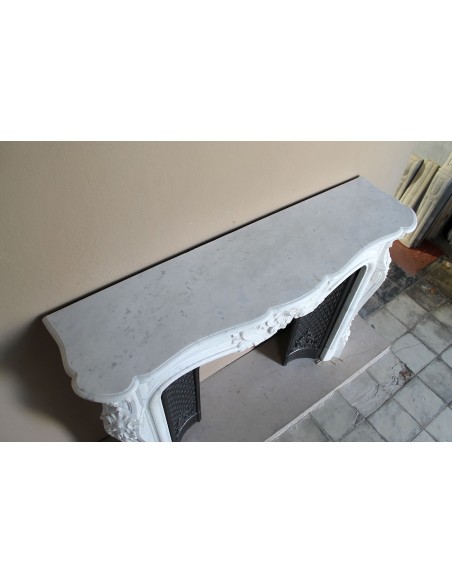 Camino antico Luigi XV "Moustache" in marmo Bianco Carrara "Puro" con controcuore in ghisa artistica a decori floreali.