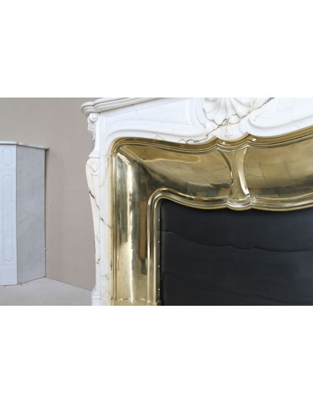 Eccezionale camino Luigi XV "Trois Coquilles" in raro ed affascinante marmo Paonazzetto con controcuore dorato d'origine.