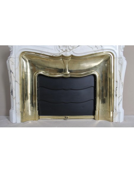 Eccezionale camino Luigi XV "Trois Coquilles" in raro ed affascinante marmo Paonazzetto con controcuore dorato d'origine.