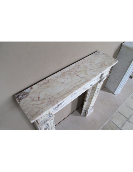 Camino neoclassico di piccola e graziosa taglia, scolpito in marmo Calacatta Oro Gold, con decori floreali.