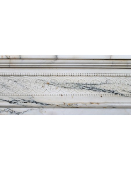 Camino neoclassico "Macaron" con elementi scultorei floreali, perlage, a colonna. Provvisto di controcuore in ghisa.