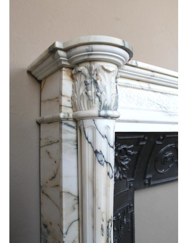 Camino neoclassico "Macaron" con elementi scultorei floreali, perlage, a colonna. Provvisto di controcuore in ghisa.