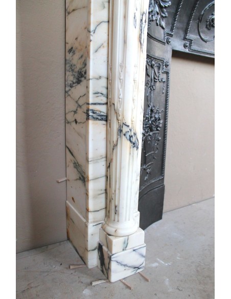 Camino neoclassico "Macaron" con elementi scultorei floreali, perlage, a colonna. Provvisto di controcuore in ghisa.