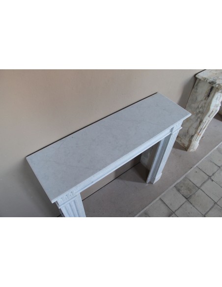 Caminetto Luigi XVI "Cannelure" scolpito in marmo Bianco "Puro" di Carrara. Un camino sobrio, elegante, lineare.