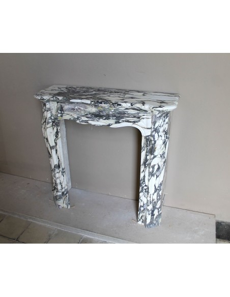 Piccolo camino barocco Pompadour in eccezionale marmo Breccia Medicea, con forti venature viola, verdi e oro su fondo bianco.