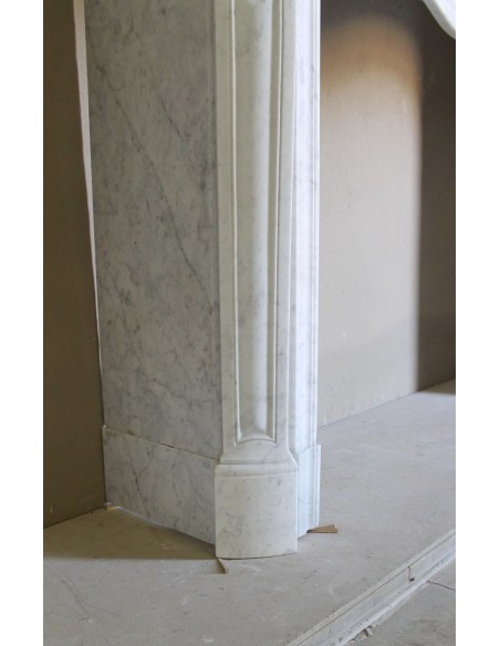 Camino barocco in marmo bianco con sculture e decori a conchiglie. Una cornice in marmo da camino autentica e antica.