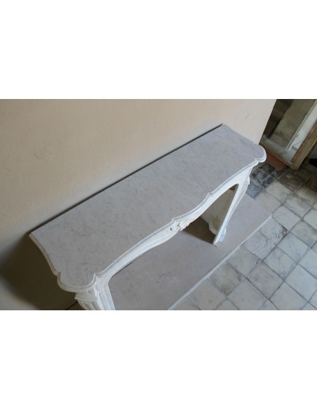 Camino barocco in marmo bianco con sculture e decori a conchiglie. Una cornice in marmo da camino autentica e antica.