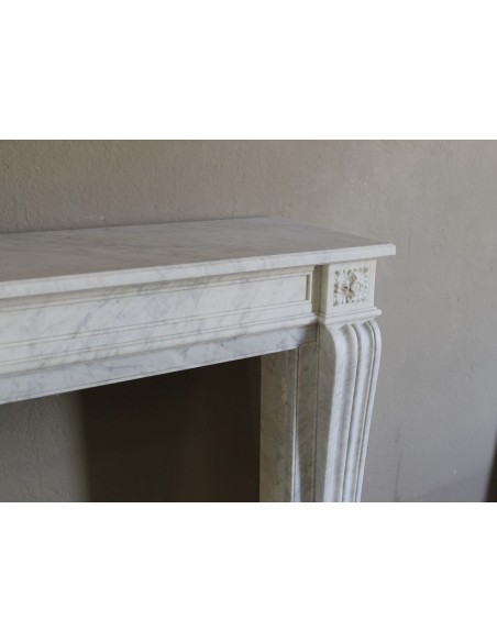Piccolo e proporzionato caminetto Neoclassico "Due Rose" a spalla mossa in marmo Bianco Carrara, molto elegante e raffinato.