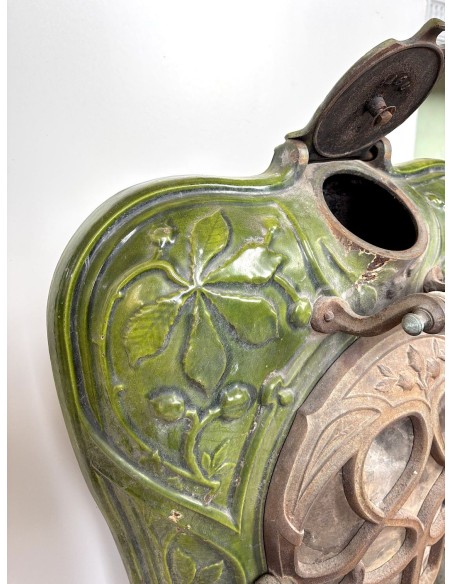 Antica stufa "Lux" in ghisa smaltata di colore verde, con decori floreali e fogliacei. Un caminetto autentico, originale, raro.