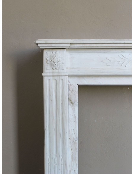 Camino antico neoclassico con decoro a ramo d'ulivo in marmo Cremo Delicato, a prezzo scontato.