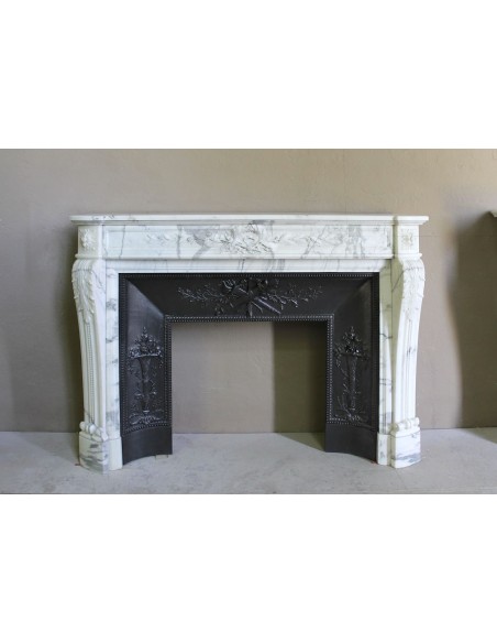 Camino antico neoclassico "Ramo d'ulivo" scolpito in marmo Bianco venato Arabescato provvisto di controcuore in ghisa d'arte.