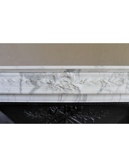 Camino antico neoclassico "Ramo d'ulivo" scolpito in marmo Bianco venato Arabescato provvisto di controcuore in ghisa d'arte.
