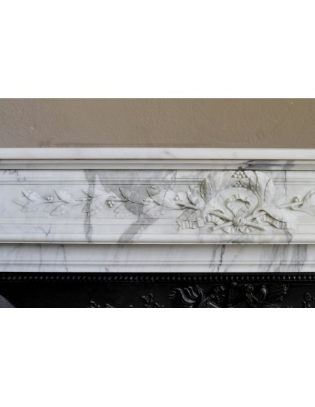 Camino antico neoclassico "Ramo d'ulivo" scolpito in marmo Bianco venato Arabescato provvisto di controcuore in ghisa d'arte.
