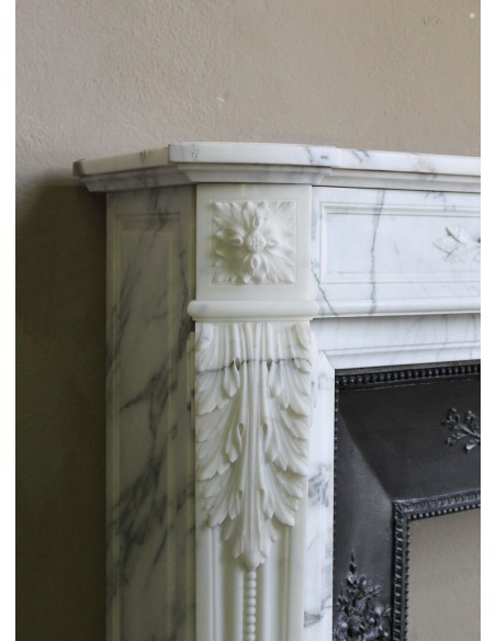 Camino antico neoclassico "Ramo d'ulivo" scolpito in marmo Bianco venato Arabescato provvisto di controcuore in ghisa d'arte.