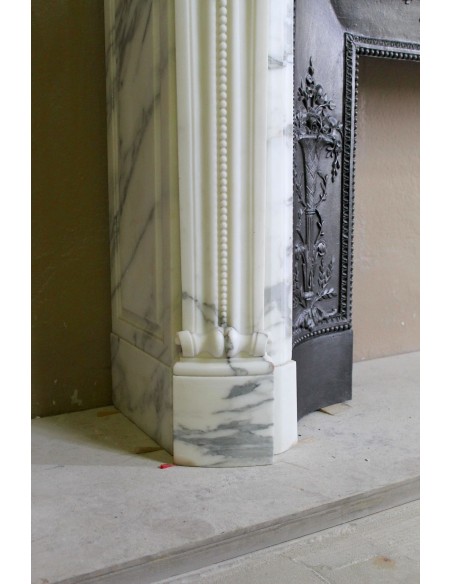 Camino antico neoclassico "Ramo d'ulivo" scolpito in marmo Bianco venato Arabescato provvisto di controcuore in ghisa d'arte.