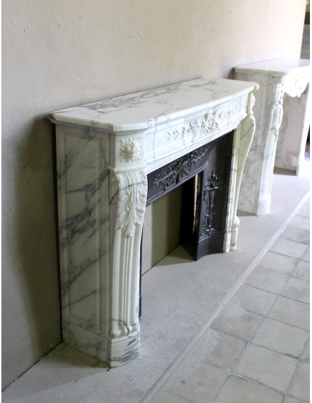 Camino antico neoclassico "Ramo d'ulivo" scolpito in marmo Bianco venato Arabescato provvisto di controcuore in ghisa d'arte.