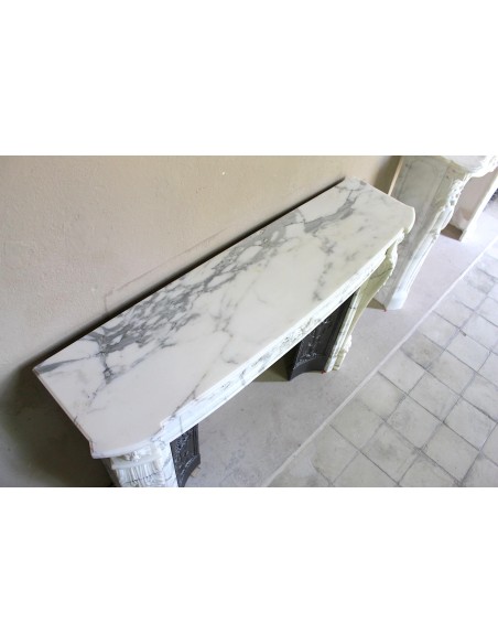 Camino antico neoclassico "Ramo d'ulivo" scolpito in marmo Bianco venato Arabescato provvisto di controcuore in ghisa d'arte.