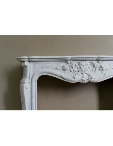 Elegante e ricercato camino in marmo bianco "Pied Galbé" con tripudio di elementi floreali scolpiti nel centro del frontale.