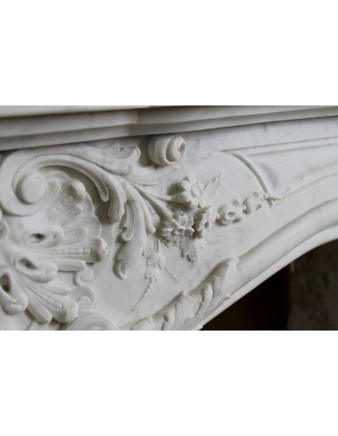 Elegante e ricercato camino in marmo bianco "Pied Galbé" con tripudio di elementi floreali scolpiti nel centro del frontale.