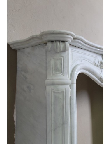 Elegante e ricercato camino in marmo bianco "Pied Galbé" con tripudio di elementi floreali scolpiti nel centro del frontale.
