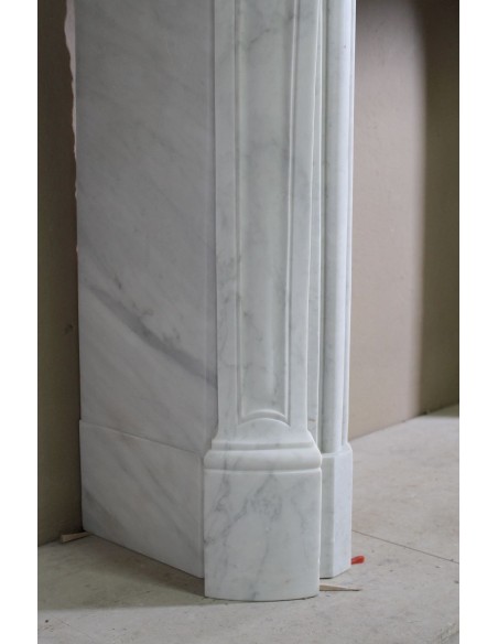 Elegante e ricercato camino in marmo bianco "Pied Galbé" con tripudio di elementi floreali scolpiti nel centro del frontale.