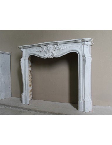 Elegante e ricercato camino in marmo bianco "Pied Galbé" con tripudio di elementi floreali scolpiti nel centro del frontale.