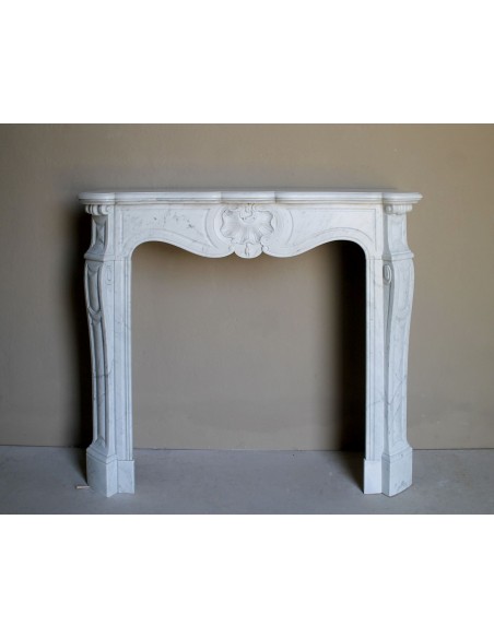 Camino antico barocco in marmo Bianco Carrara arricchito dalla scultura di una conchiglia al centro e riccioli sui capitelli.