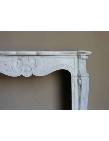 Camino antico barocco in marmo Bianco Carrara arricchito dalla scultura di una conchiglia al centro e riccioli sui capitelli.