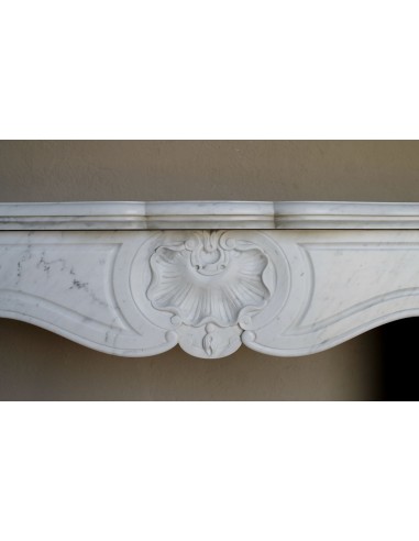 Camino antico barocco in marmo Bianco Carrara arricchito dalla scultura di una conchiglia al centro e riccioli sui capitelli.