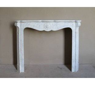 Caminetto antico barocco "Pompadour" scolpito in marmo bianco Carrara recante la scultura di una rosa al centro del frontale.