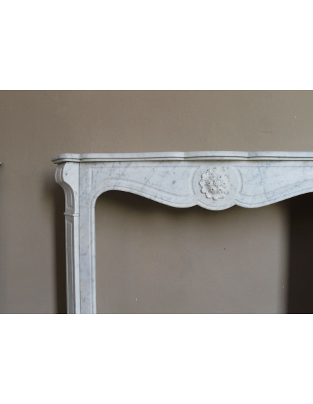 Caminetto antico barocco "Pompadour" scolpito in marmo bianco Carrara recante la scultura di una rosa al centro del frontale.