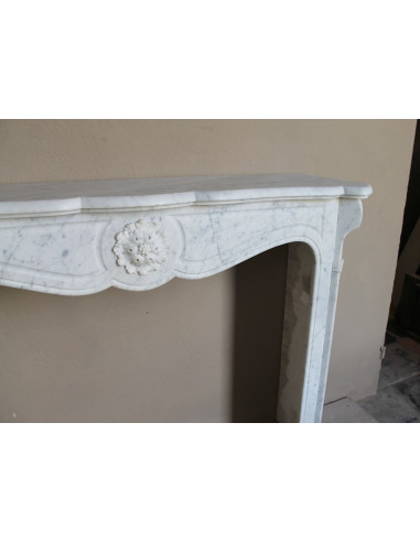 Caminetto antico barocco "Pompadour" scolpito in marmo bianco Carrara recante la scultura di una rosa al centro del frontale.
