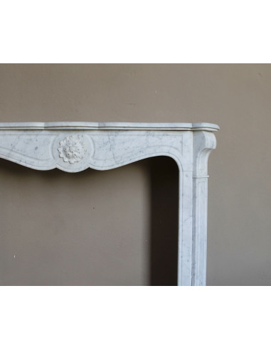 Caminetto antico barocco "Pompadour" scolpito in marmo bianco Carrara recante la scultura di una rosa al centro del frontale.