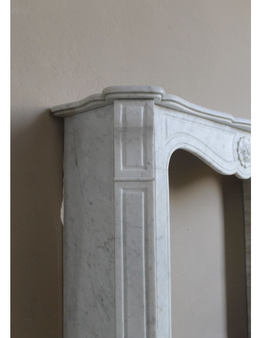Caminetto antico barocco "Pompadour" scolpito in marmo bianco Carrara recante la scultura di una rosa al centro del frontale.