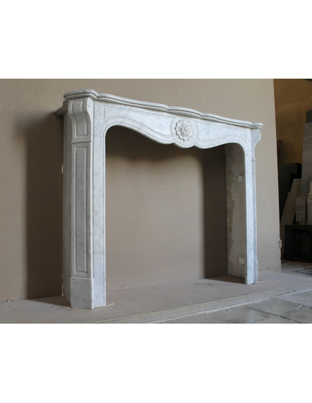 Caminetto antico barocco "Pompadour" scolpito in marmo bianco Carrara recante la scultura di una rosa al centro del frontale.