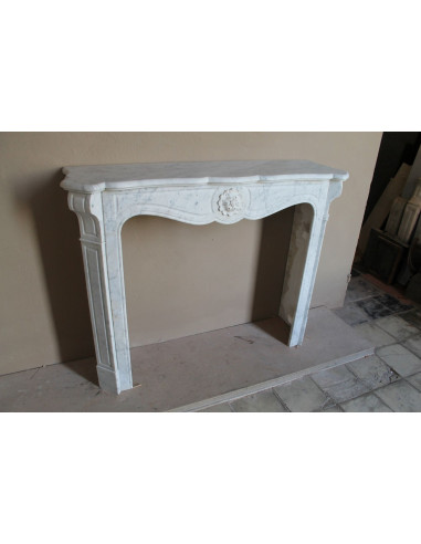 Caminetto antico barocco "Pompadour" scolpito in marmo bianco Carrara recante la scultura di una rosa al centro del frontale.