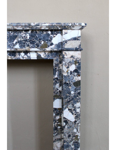Camino antico neoclassico in marmo policromo, dalle linee minimaliste e dalle eleganti venature oro, bianco e nero.