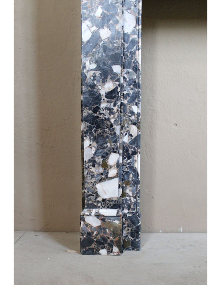 Camino antico neoclassico in marmo policromo, dalle linee minimaliste e dalle eleganti venature oro, bianco e nero.