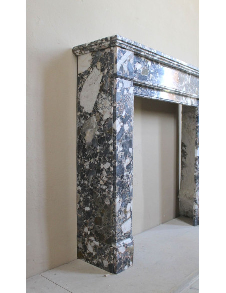 Camino antico neoclassico in marmo policromo, dalle linee minimaliste e dalle eleganti venature oro, bianco e nero.