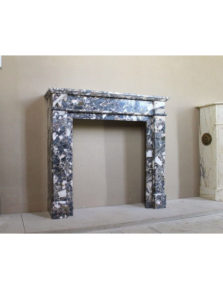 Camino antico neoclassico in marmo policromo, dalle linee minimaliste e dalle eleganti venature oro, bianco e nero.