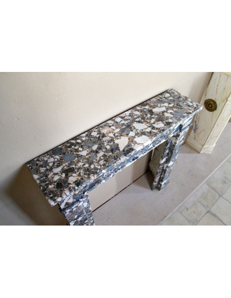 Camino antico neoclassico in marmo policromo, dalle linee minimaliste e dalle eleganti venature oro, bianco e nero.